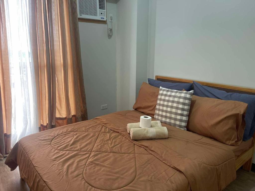 a bedroom with a bed with two towels on it at Verdon Parc Davao City with Balcony by darpm in Davao City
