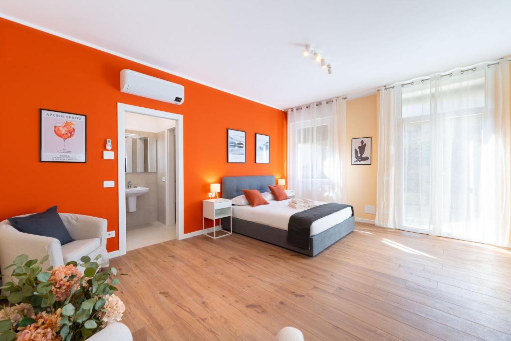 a bedroom with orange walls and a bed and a chair at La Nuova Corte Rooms in Verona