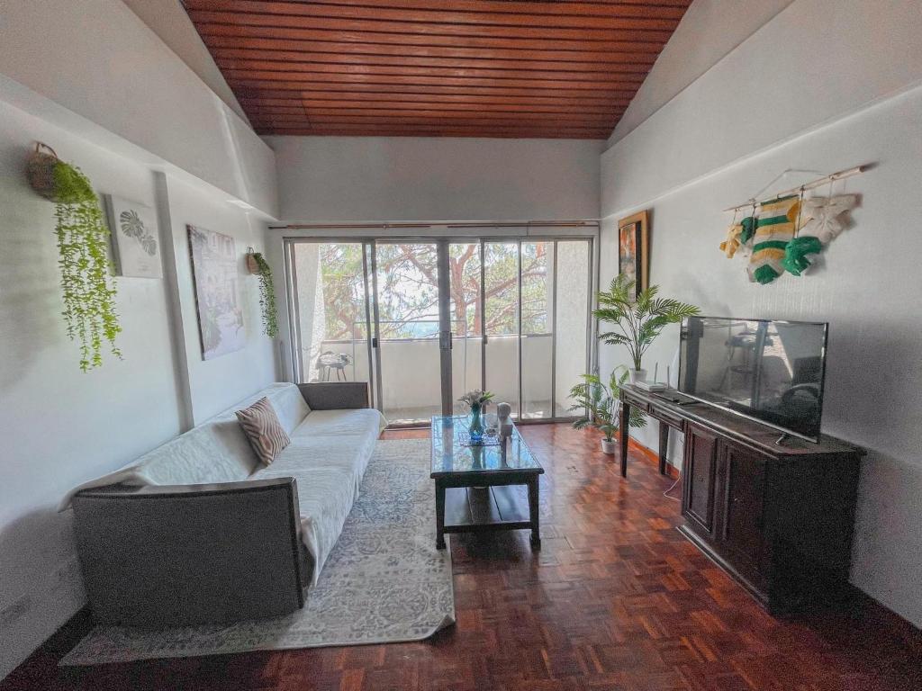 - un salon avec un canapé et un aquarium dans l'établissement Baguio Feels Staycation, à Baguio