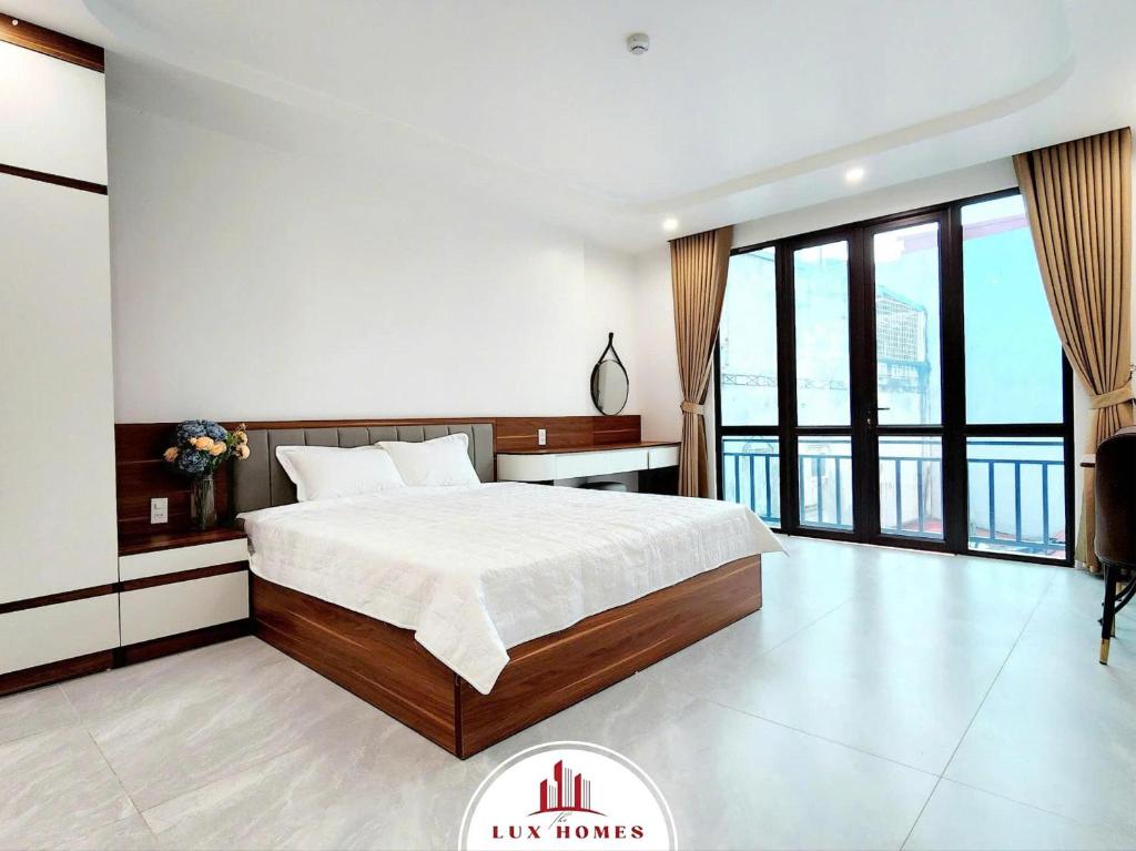 a bedroom with a large bed and a large window at The LuxHomes Apartment ᵀᴹ I 231 Văn Cao in Hai Phong