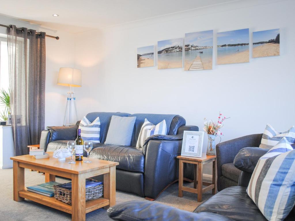 a living room with a blue couch and a table at Rock Point in Salcombe