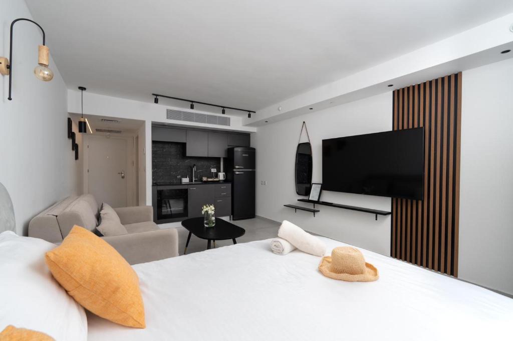 een slaapkamer met een wit bed en een woonkamer bij סי סייד אילת חדר משפחתי מפנק עם נוף לים in Eilat