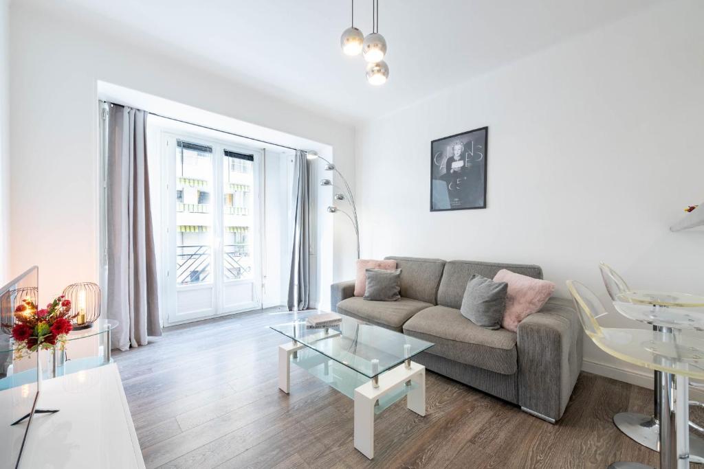 un salon avec un canapé et une table dans l'établissement 1-Br Apartment in Cannes Walk to the Beach, à Cannes