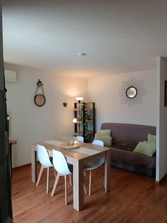 une salle à manger avec une table, des chaises et un canapé dans l'établissement les sables d'or grau du roi, au Grau-du-Roi