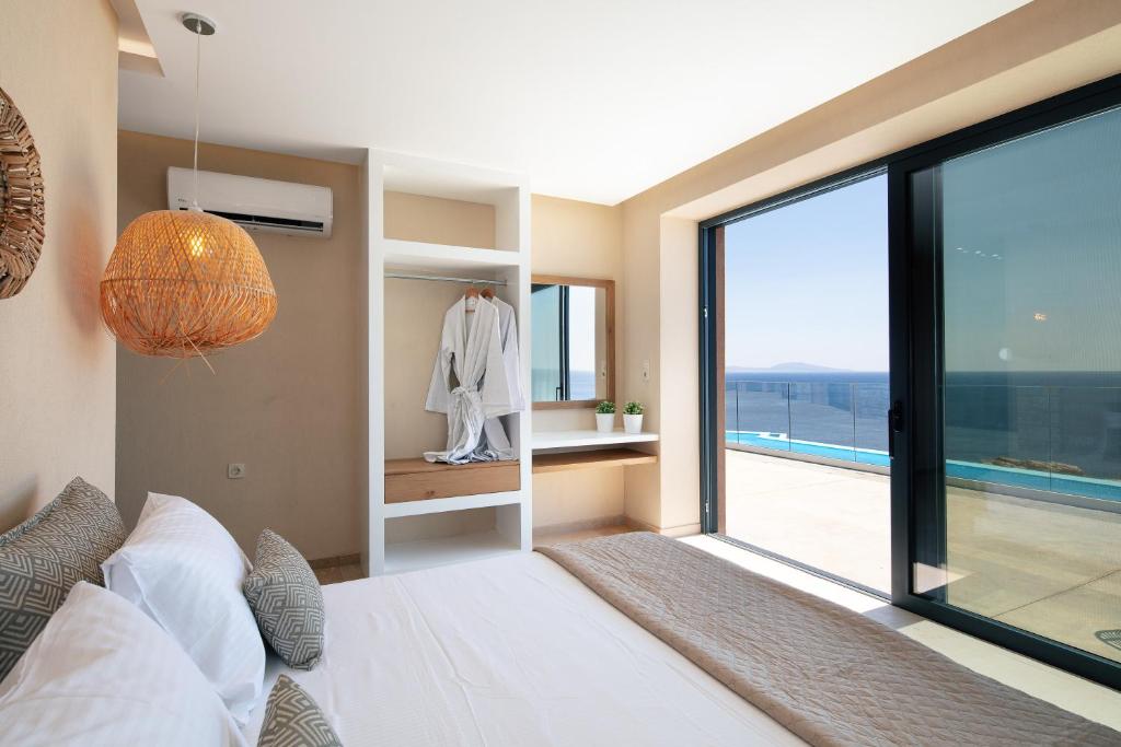 Postel nebo postele na pokoji v ubytování Seafront elegant villas, with infinity pools & devine views!