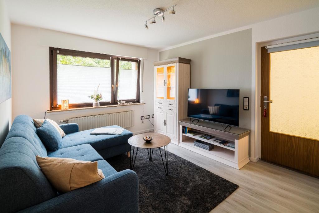 a living room with a blue couch and a tv at Ferienwohnung an der Volme in Meinerzhagen