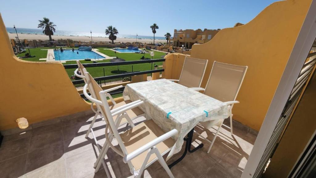 un balcone con tavolo e sedie e una piscina di 142 - Livingtarifa Mango a Tarifa