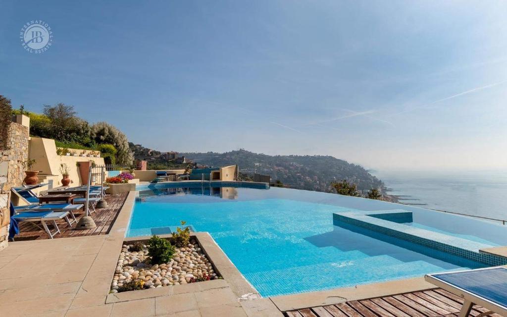 a large swimming pool with a view of the ocean at Villa Paradise-Sleeps 20-Pool-Sea Views-pets in Ospedaletti