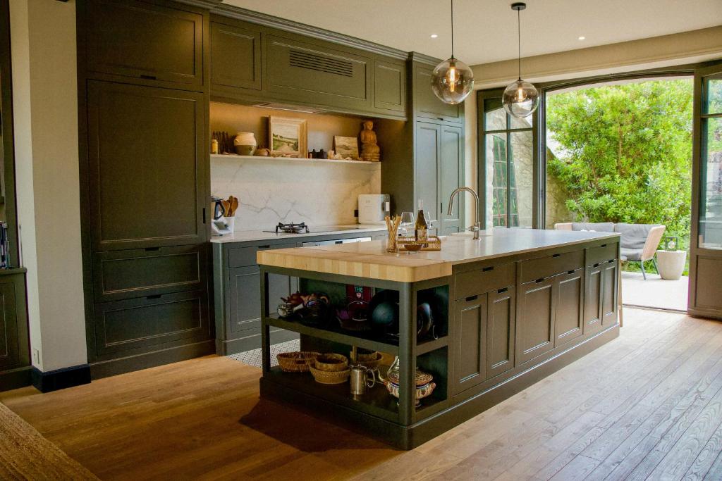 une cuisine avec des placards verts et un îlot de cuisine dans l'établissement Beachfront House In Loire-Atlantique, au Pouliguen