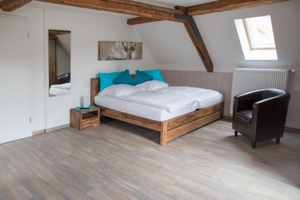 een slaapkamer met een bed, een stoel en een spiegel bij Apartment 05 in Igersheim