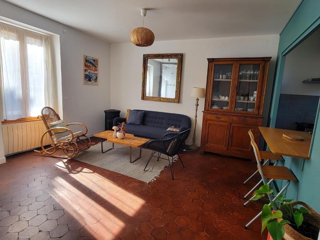 ThomeryにあるLa Bycoque, maison 2 chambres au calmeの青いソファとテーブルのあるリビングルーム