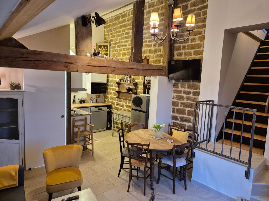 a kitchen and dining room with a table and chairs at A La Maison in Les Repôts