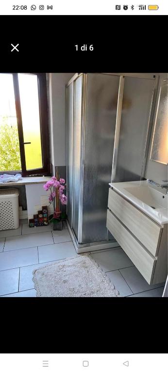 a bathroom with a refrigerator and a sink and a mirror at Casa Callisto in Asti