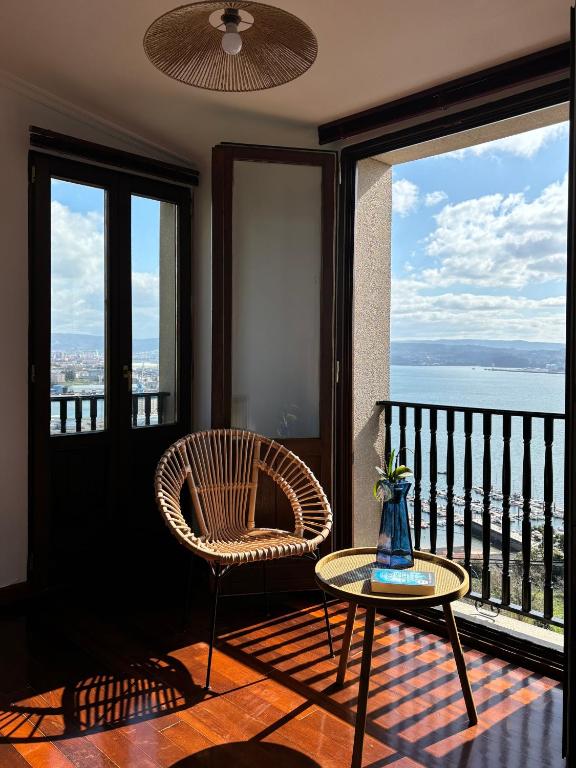 a chair and a table in a room with a balcony at Casa Martorell Ferrol in Ferrol