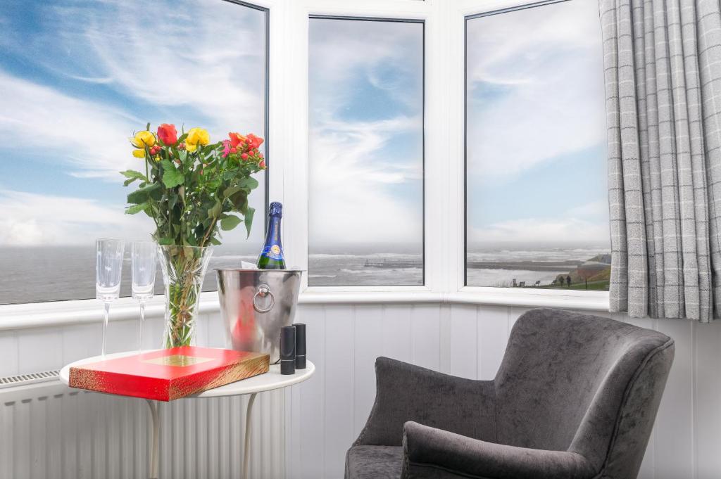 a vase of flowers on a table in front of a window at The Wheeldale in Whitby