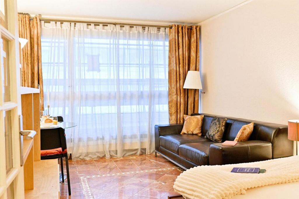 un salon avec un canapé en cuir et une fenêtre dans l'établissement Élégant et bien situé votre havre de paix à Paris, à Paris
