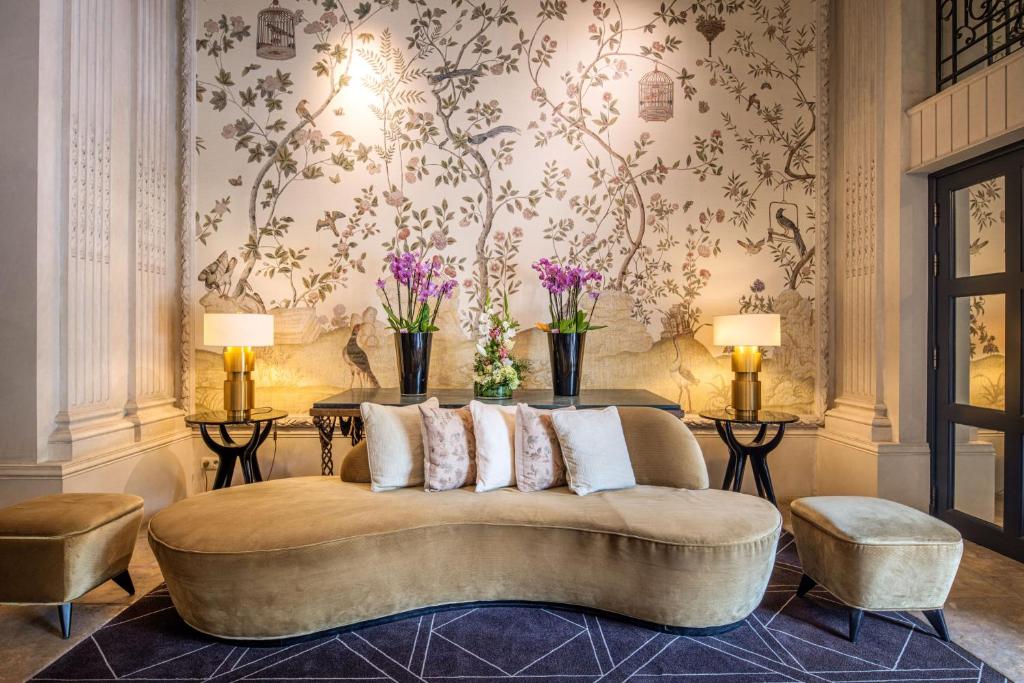 a living room with a couch and flowers on the wall at Hotel Barsey by Warwick in Brussels