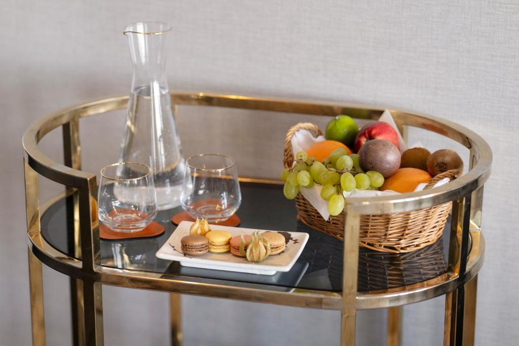 a table with a basket of fruit and wine glasses at Hotel Barsey by Warwick in Brussels