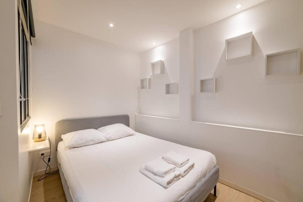 - une chambre blanche avec un lit et des serviettes dans l'établissement Biau - Séjour à Auxerre, à Auxerre