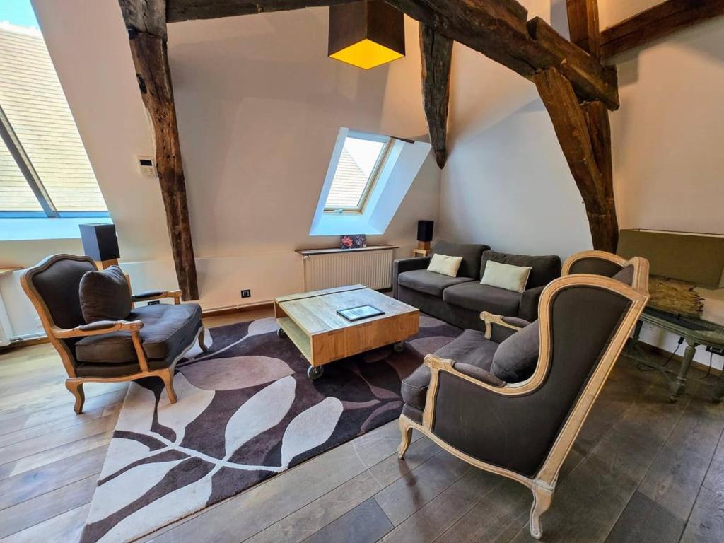 un salon avec un canapé, des chaises et une table dans l'établissement Robillard 2 - Séjour à Auxerre, à Auxerre