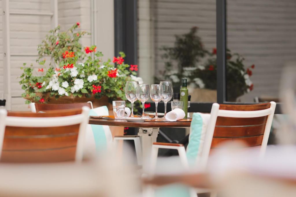 a wooden table with wine glasses and flowers on it at Hotel Barsey by Warwick in Brussels