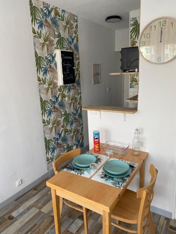 une cuisine avec une table avec deux assiettes dessus dans l'établissement Appartements parfaits pour Cures Thermales, au bord de l’Etang de Thau, à Balaruc-les-Bains