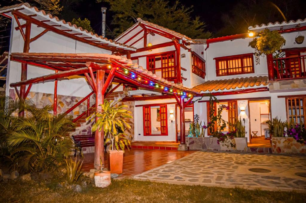 a white house with christmas lights on it at Casa Aminta in Curití