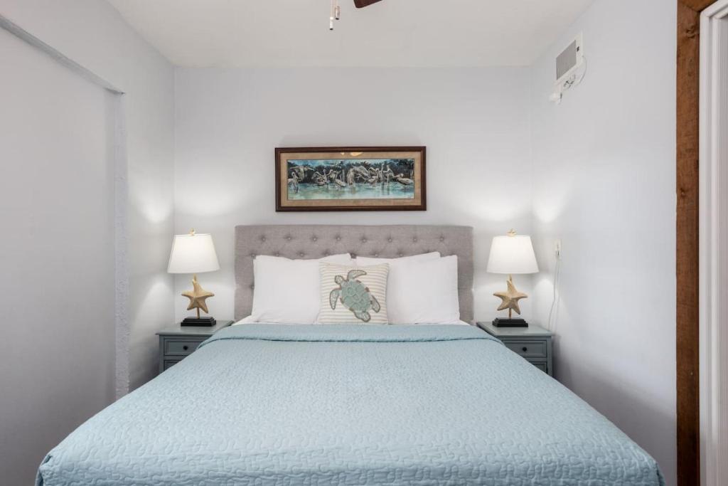 una camera da letto con un letto grande con due lampade di Cozy Cottage Pool Home close to Beaches a Melbourne