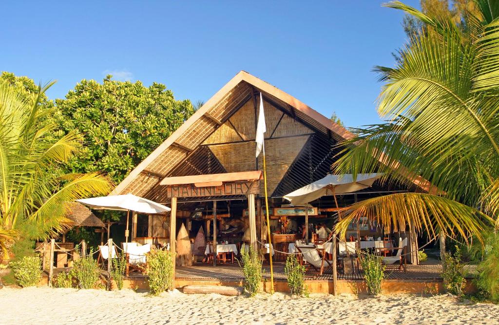 a restaurant with chairs and umbrellas on the beach at Maningory in Ile aux Nattes