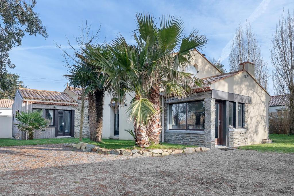 a house with palm trees in front of it at Maison avec dépendance pour 11 à 800m de la mer in La Plaine-sur-Mer