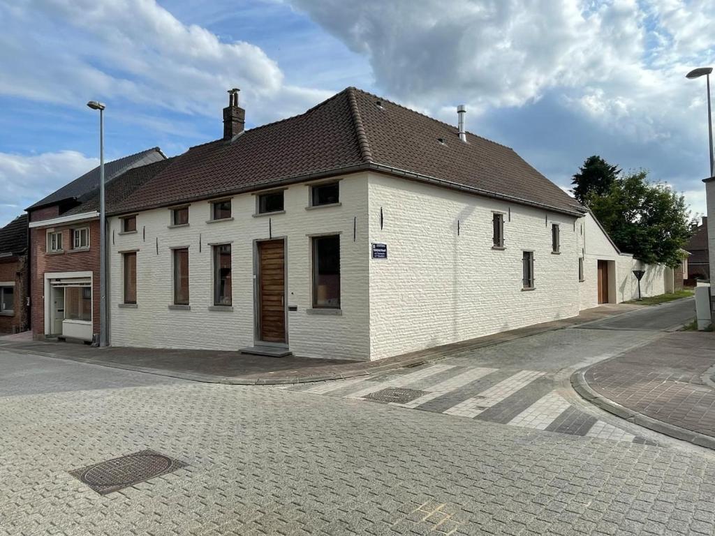 a white building with a brown roof on a street at Zarlar House in Geraardsbergen