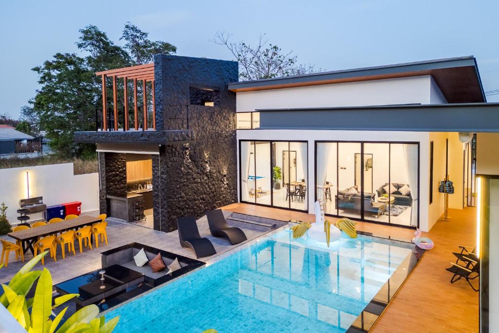 a villa with a swimming pool and a house at Black Rocher Poolvilla Huahin in Hua Hin