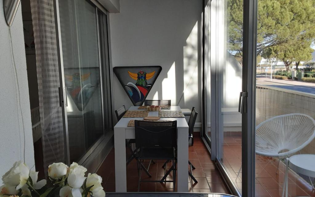Elle comprend un petit balcon avec une table et des chaises. dans l'établissement AS23988-Studio cabine, dans une Résidence directe sur Plage, au Grau-du-Roi