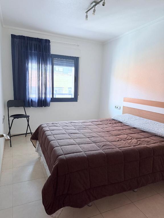 a bedroom with a bed and a chair and a window at Alicante Hills 1 in Alicante