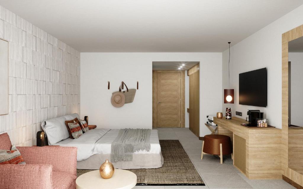 a hotel room with a bed and a tv at Golden Milos Beach Ηouse by Domotel in Provatas