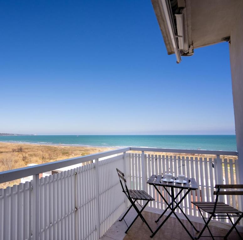 a balcony with a table and chairs and the ocean at Onda del cielo in San Salvo