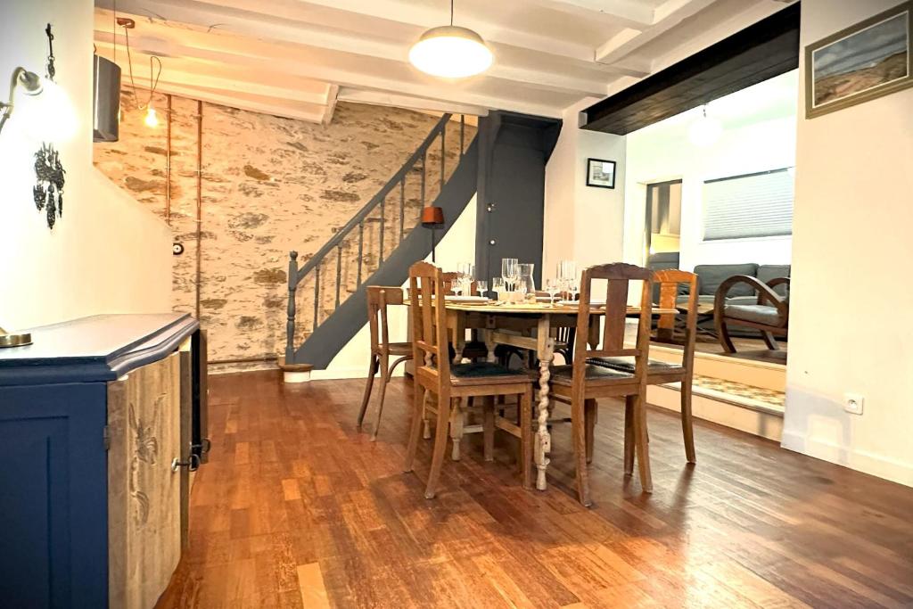 une salle à manger avec une table et des chaises et un escalier dans l'établissement L'Octroi-Maison au calme avec jardin, à Nantes