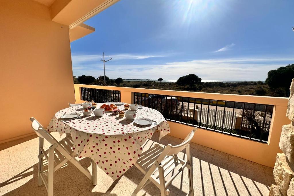 une table et des chaises sur un balcon avec vue dans l'établissement Le Reflet des mers - P3 première ligne vue mer et parking, au Grau-du-Roi