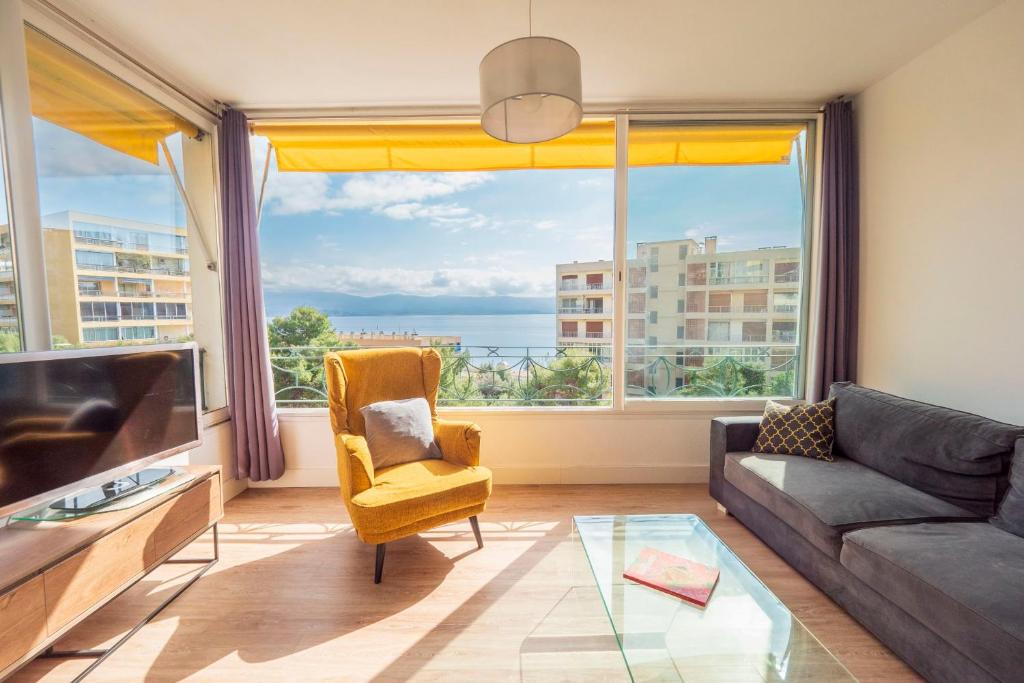 un salon avec un canapé et une grande fenêtre dans l'établissement Valentina - Sea view Luminous Calm - by TGB, à Ajaccio