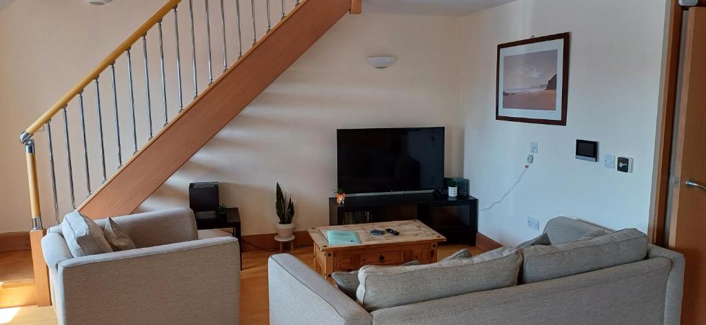 a living room with two couches and a tv at Marina Outlook in Milford Haven