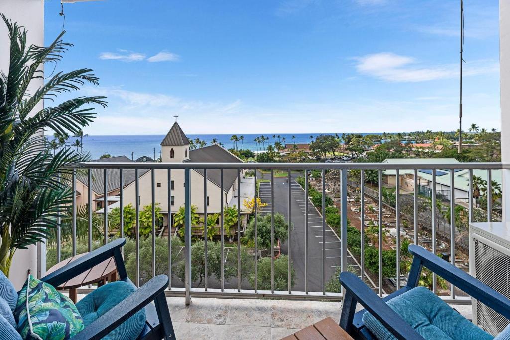 a balcony with chairs and a view of the ocean at Kailua Village#705 in Kailua-Kona
