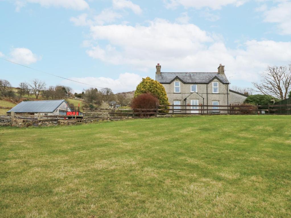 ein großes Haus mit einem Feld davor in der Unterkunft Dalar Cottage in Brynkir