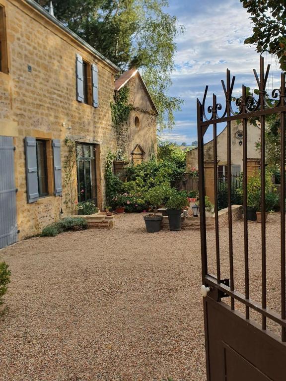 une porte ouverte menant à un bâtiment avec une cour dans l'établissement L'Echappée Belle entre Loire et Collines, à Iguerande