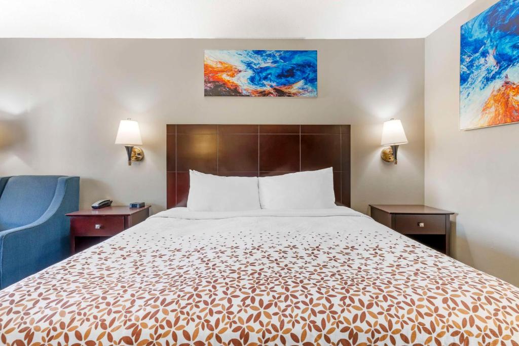 a hotel room with a bed and a blue chair at Best Western Royal Inn in Chattanooga