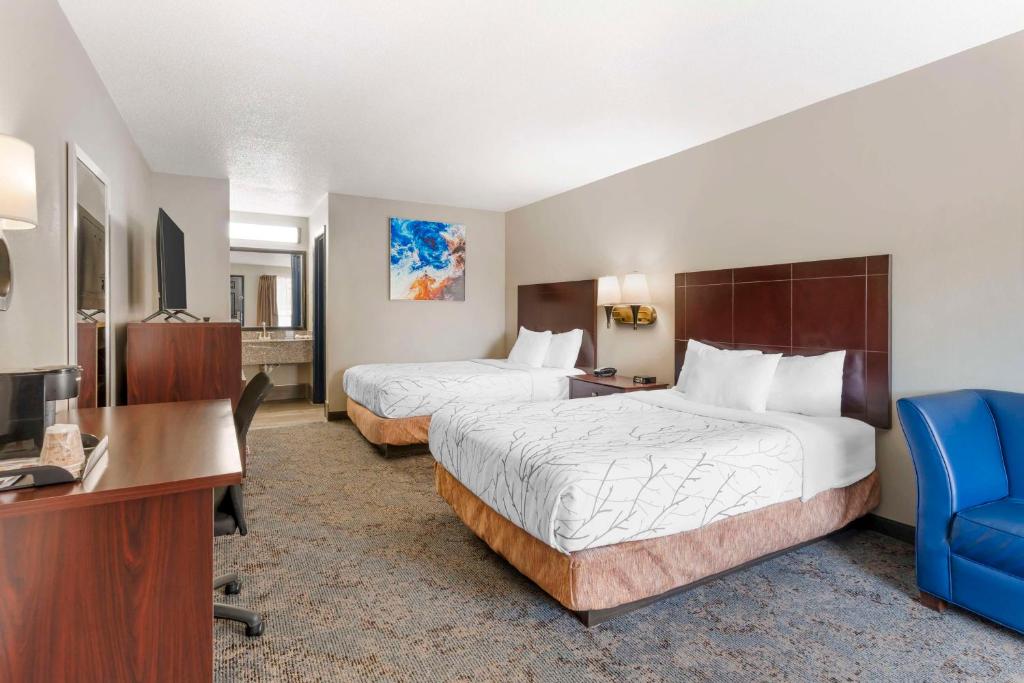 a hotel room with two beds and a desk at Best Western Royal Inn in Chattanooga