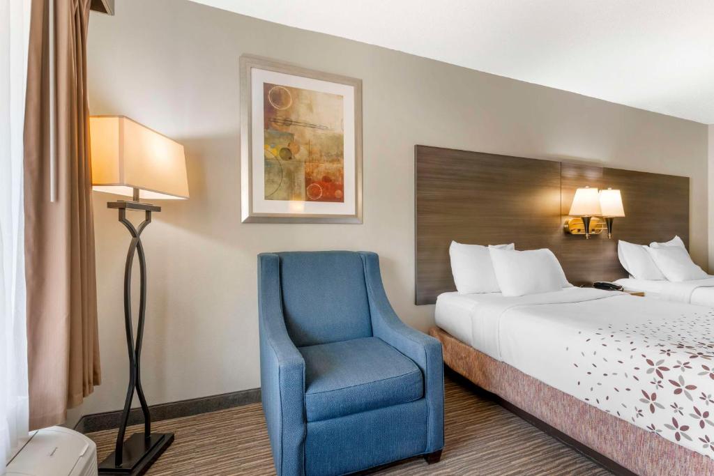 a hotel room with a bed and a blue chair at Best Western Royal Inn in Chattanooga