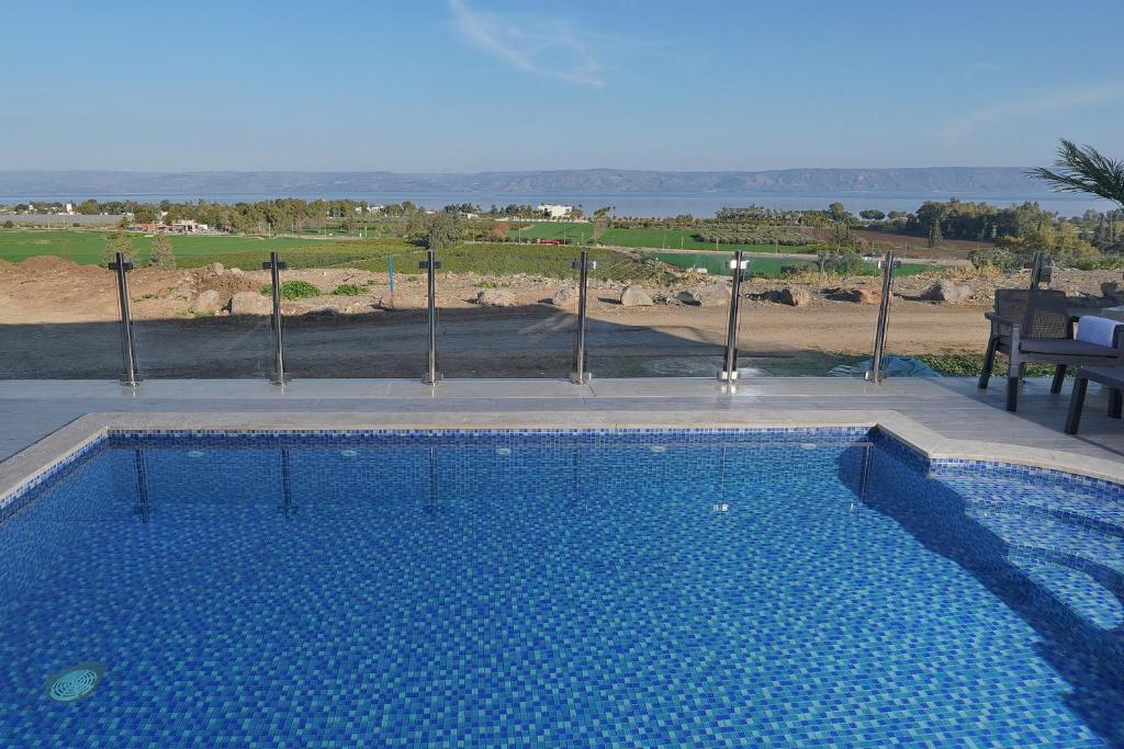 a large swimming pool with a view of the ocean at Levication Villa - Private Pool - Lakefront Migdal in Migdal