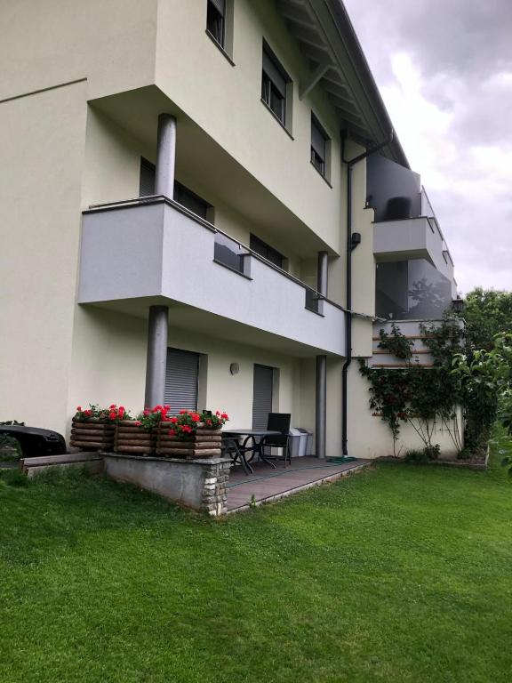 biały budynek z czerwonymi kwiatami na podwórku w obiekcie Ferienwohnung Reinstadler Ilse w mieście Jerzens