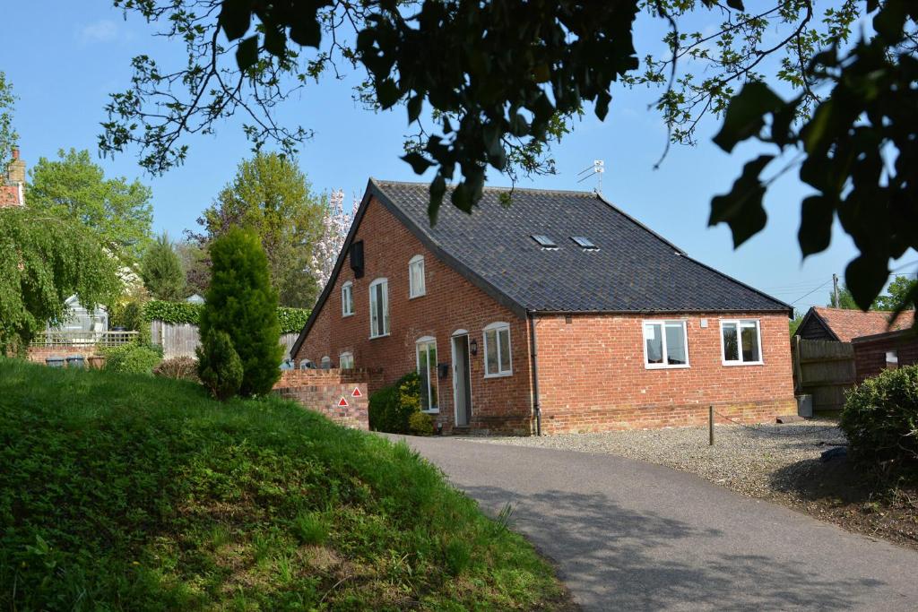 a red brick house with a black roof at 1 The Old Coach House in Laxfield