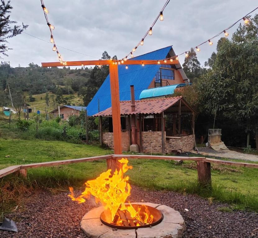 a fire pit in front of a blue building at Cabaña Campestre Las Marías in Paipa
